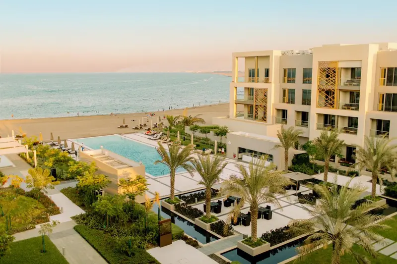 Vue aérienne d'un complexe hôtelier avec piscine et plage.