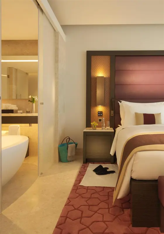 Une chambre lumineuse avec un grand lit et une salle de bain attenante.