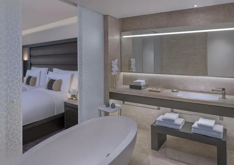 Une salle de bain moderne avec une baignoire et un grand miroir éclairé.