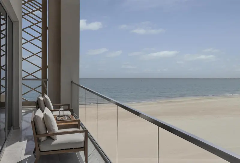 Terrasse avec mobilier d'extérieur donnant sur une plage de sable.