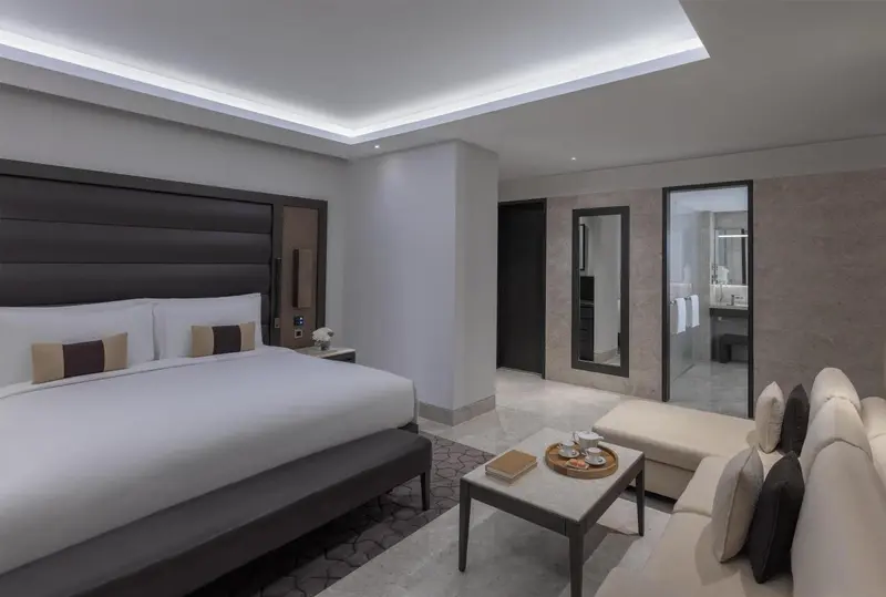 Une chambre lumineuse avec un grand lit et un coin salon.