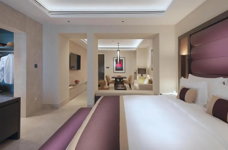 Une chambre spacieuse avec un lit king-size et un espace salon attenant.