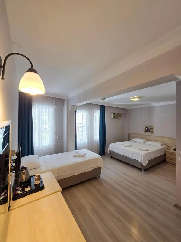 Chambre lumineuse avec deux lits simples et une décoration sobre.