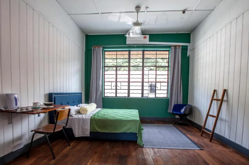 Une chambre simple avec un lit, un bureau et une fenêtre.