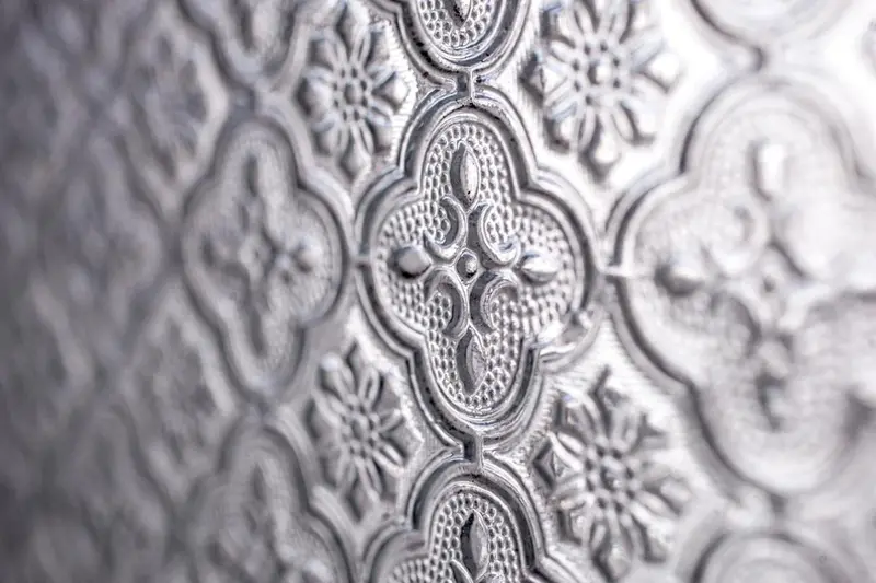 Motif ornemental en relief sur une surface métallique.