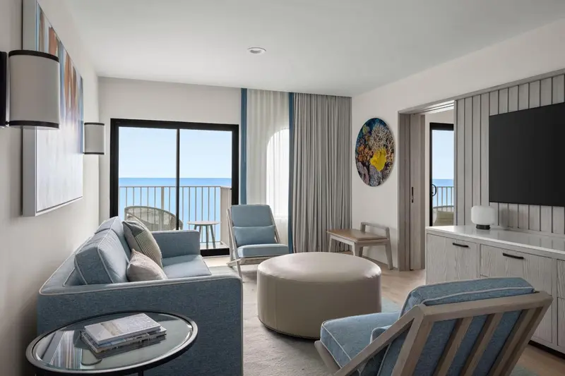 Un salon lumineux s'ouvre sur une vue mer par de grandes baies vitrées.