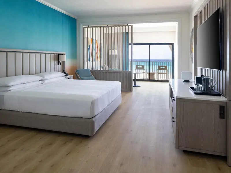 Une chambre lumineuse avec un grand lit et une vue sur la mer.