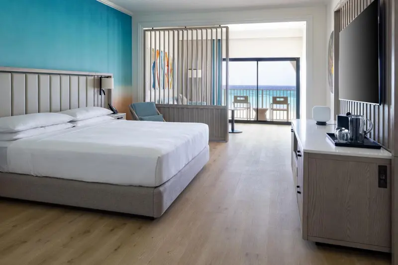 Une chambre lumineuse avec un grand lit et une vue sur la mer.