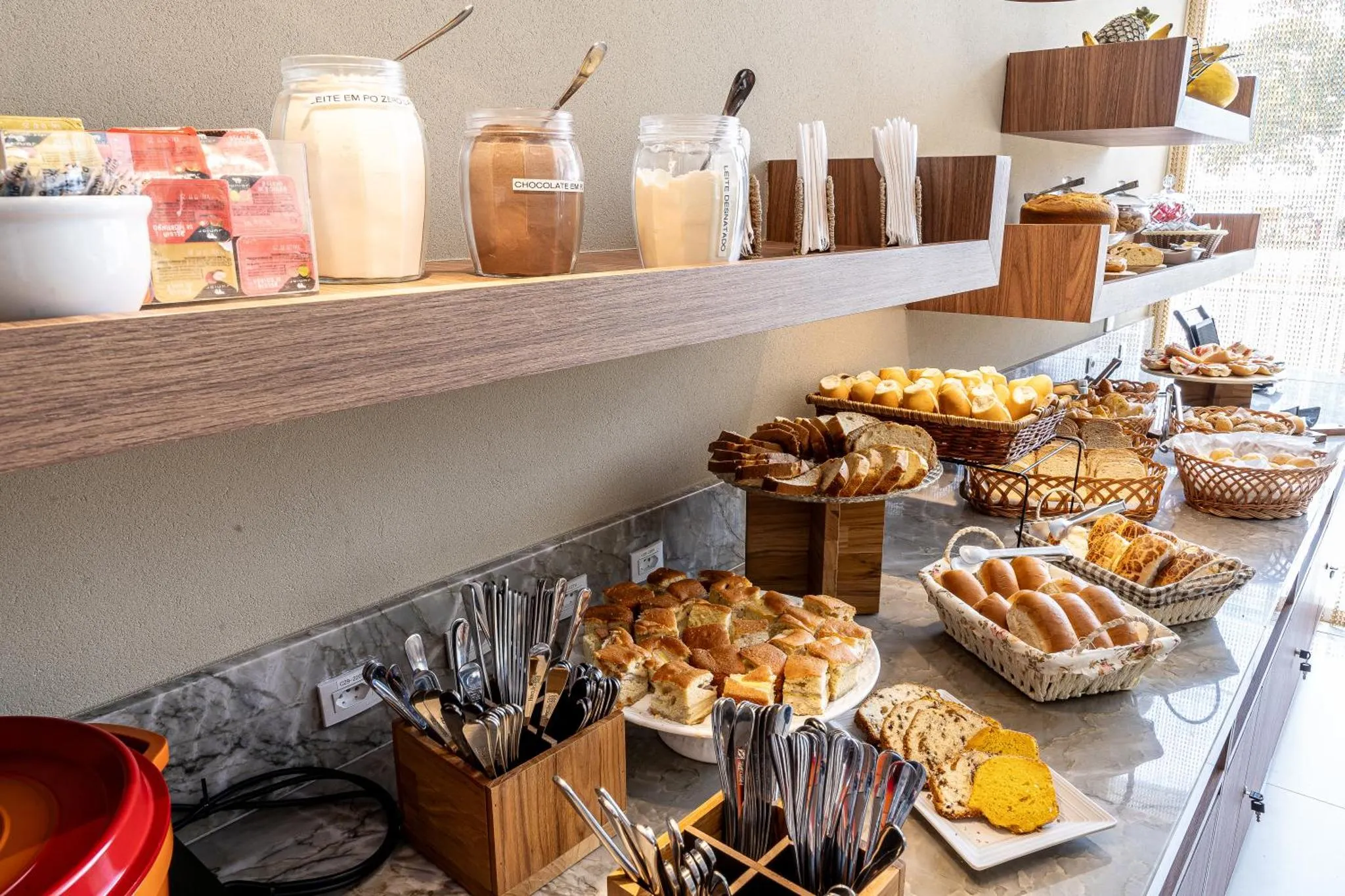 Un buffet propose diverses pâtisseries, céréales et boissons.
