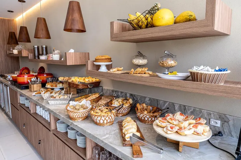 Un buffet propose une variété de pains, pâtisseries et fruits frais.
