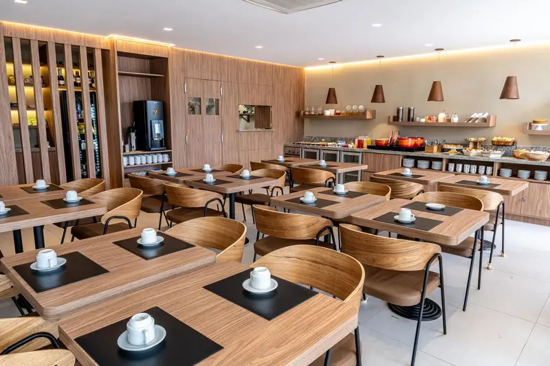Une salle lumineuse avec des tables et des chaises pour le petit-déjeuner.