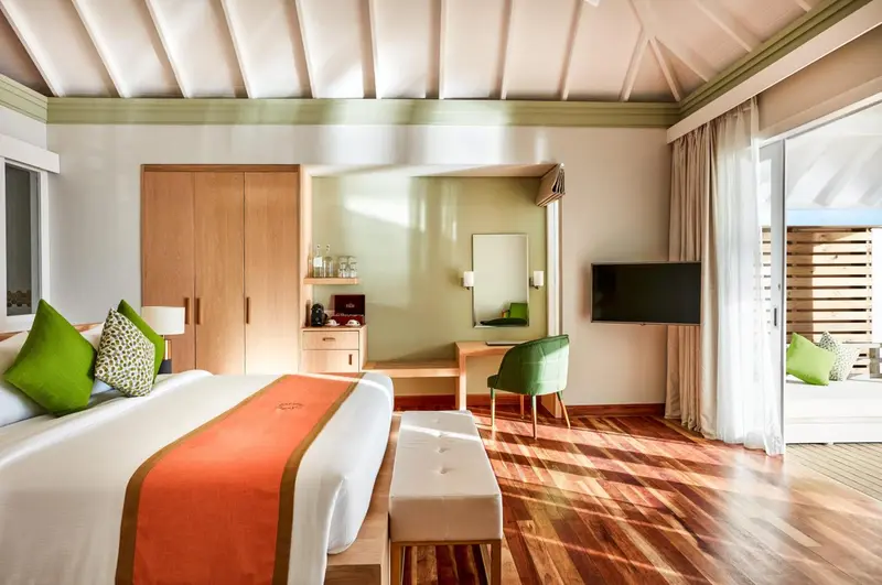 Une chambre lumineuse avec un lit double et un espace bureau.