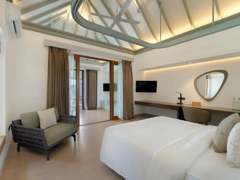 Une chambre lumineuse avec un canapé et un grand lit.