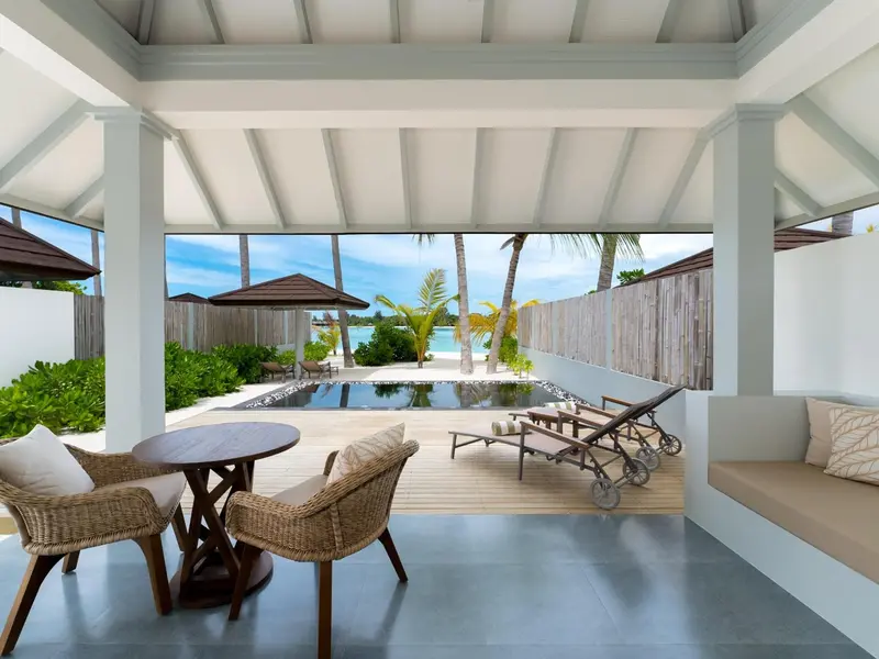 Espace de détente extérieur avec mobilier et vue sur la mer.