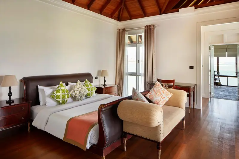 Une chambre lumineuse avec un grand lit et un coin salon.