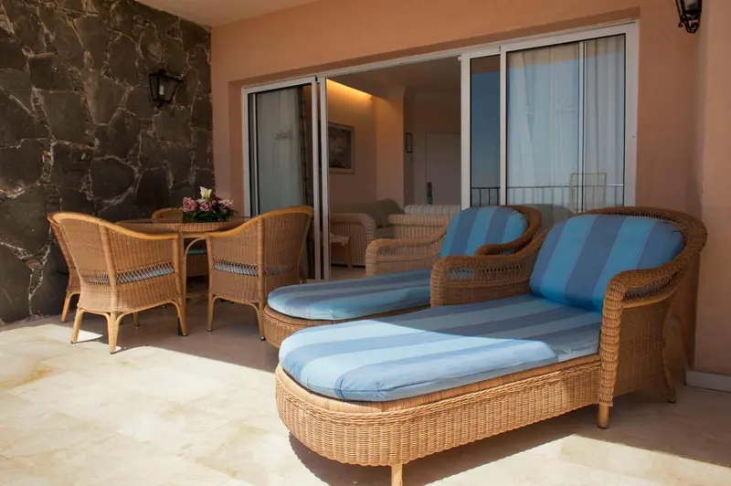 Terrasse aménagée avec mobilier en rotin et table à manger.