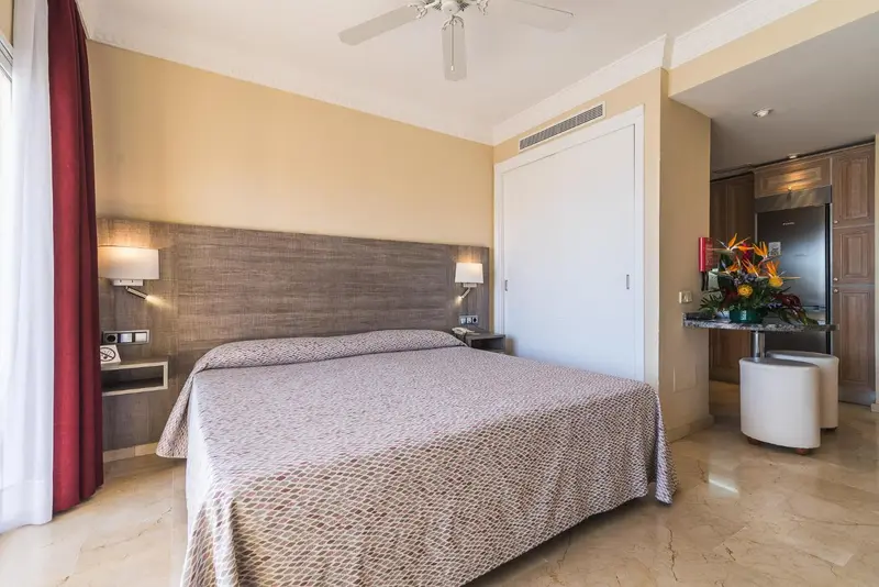 Une chambre lumineuse avec un grand lit et un espace repas.