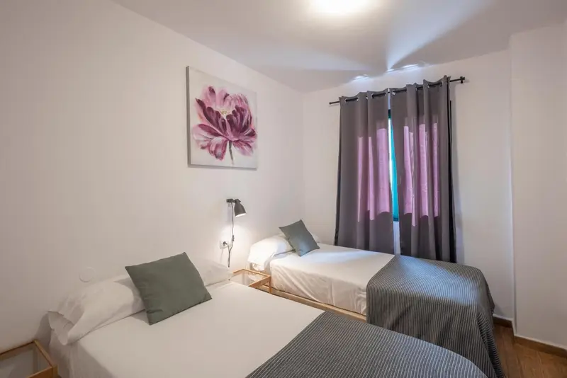 Une chambre lumineuse avec deux lits simples et une décoration florale.