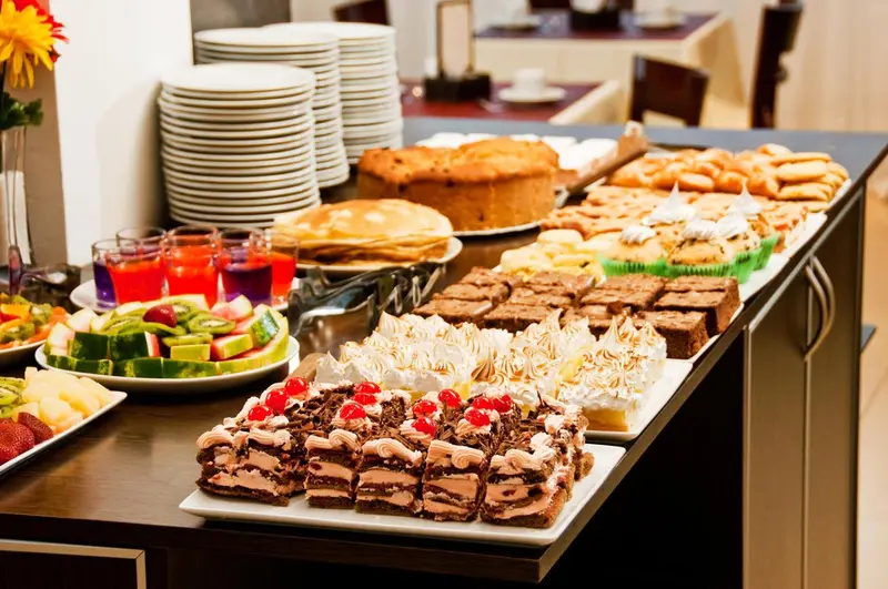 Un buffet propose une grande variété de pâtisseries et de fruits.