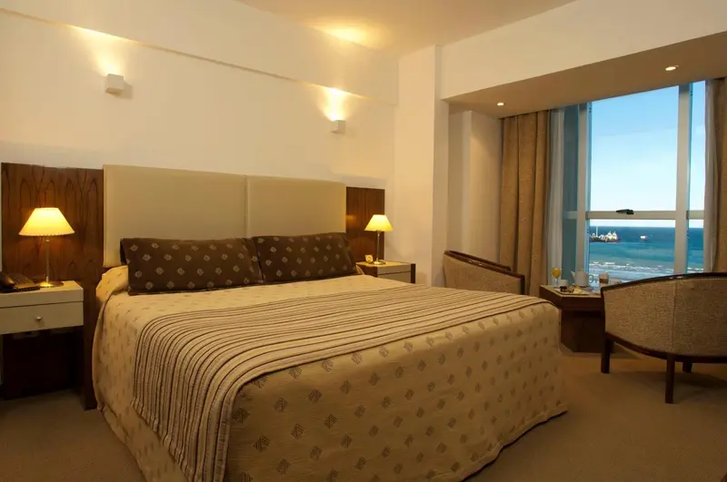 Une chambre lumineuse avec un grand lit et une vue sur la mer.