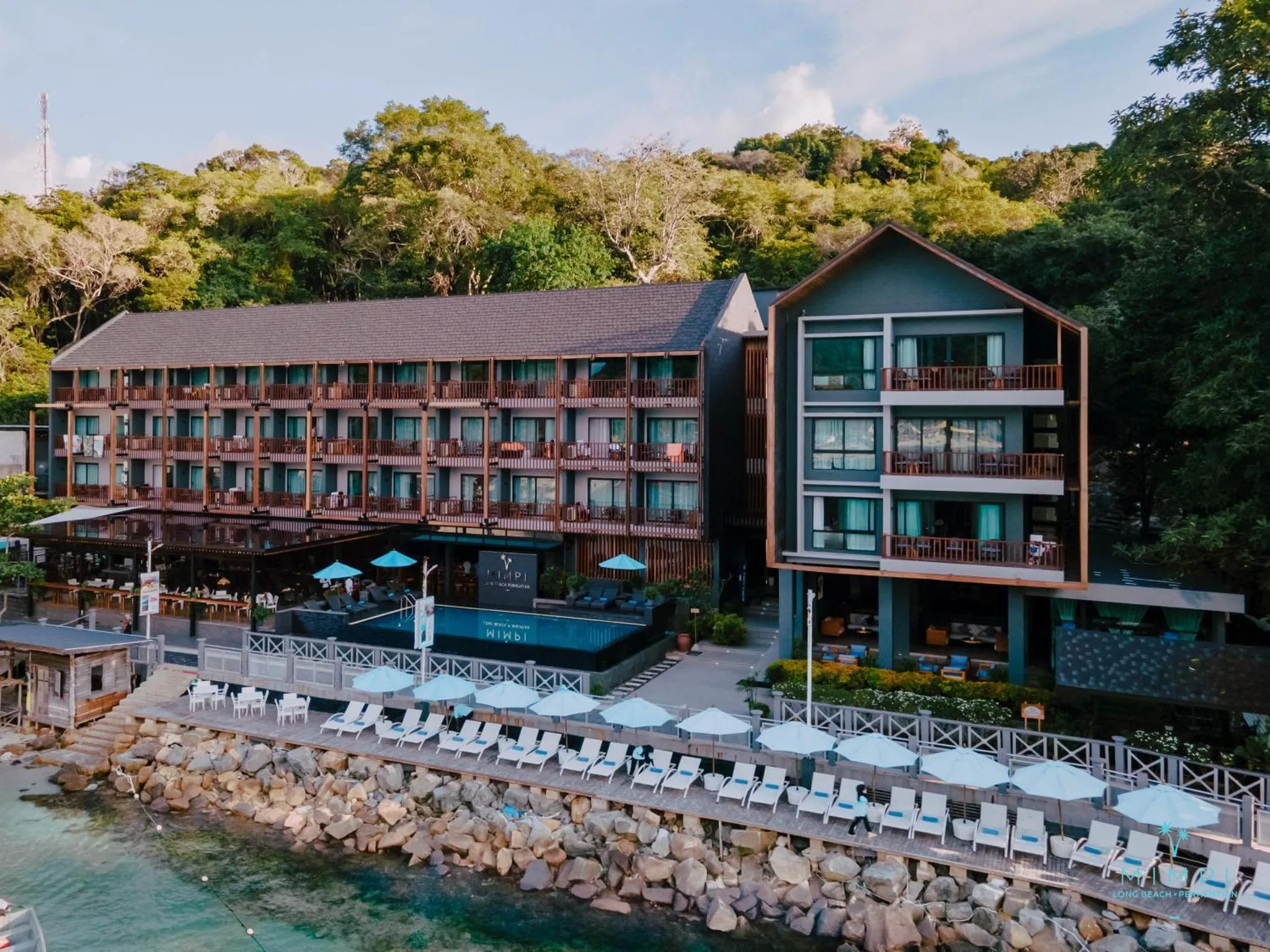 Bâtiment moderne avec piscine et terrasse en bord de mer.