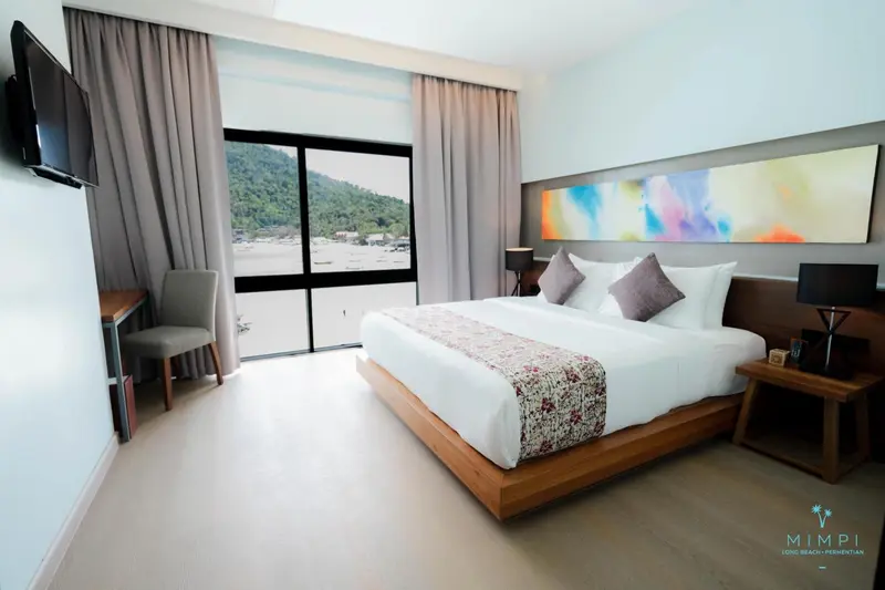 Une chambre lumineuse avec un grand lit et une vue sur la mer.
