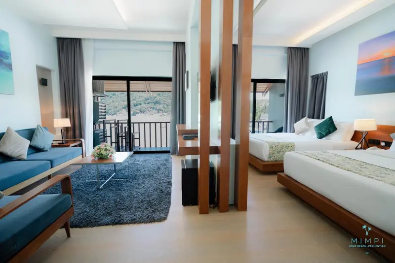 Espace de vie lumineux avec canapé bleu et lit double.