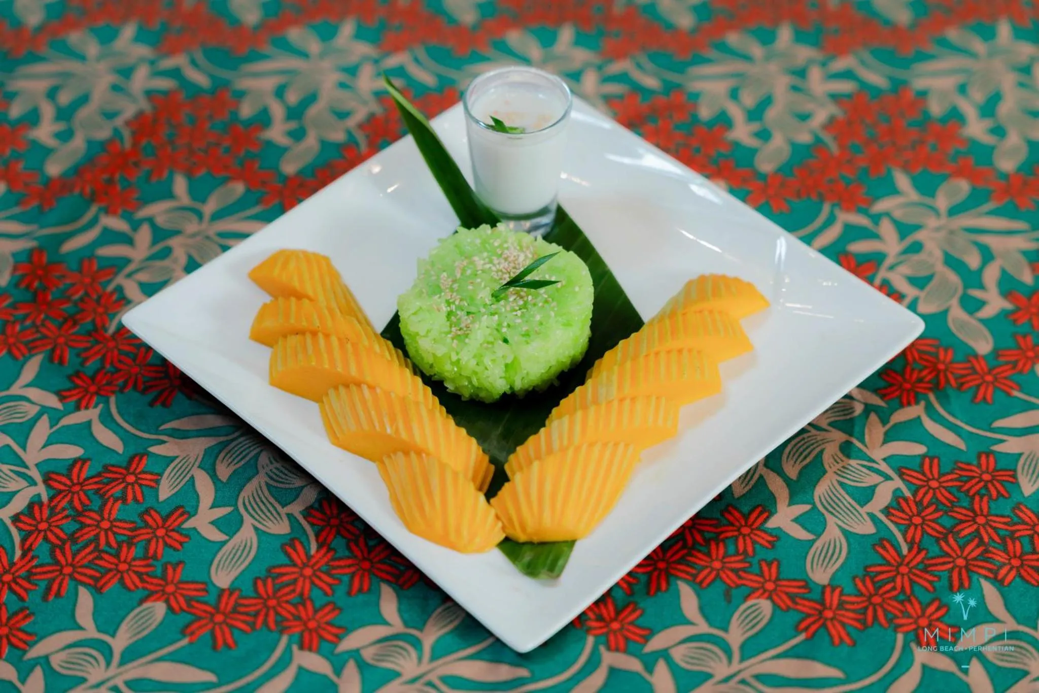 Assiette de riz gluant à la mangue décorée avec des tranches de fruit.