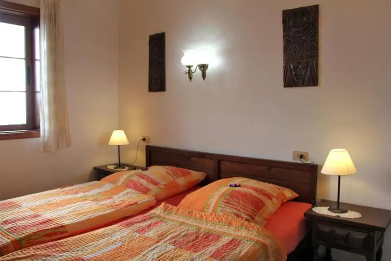 Une chambre avec deux lits simples et des lampes de chevet.