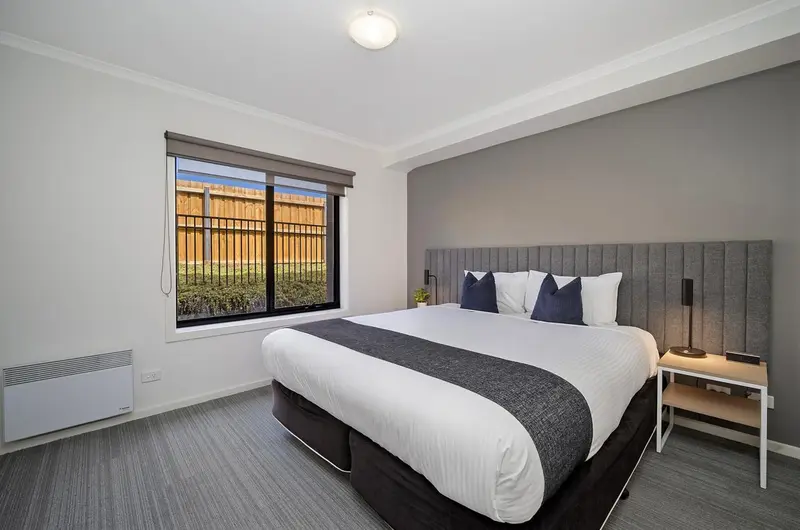 Une chambre lumineuse avec un grand lit et une fenêtre.