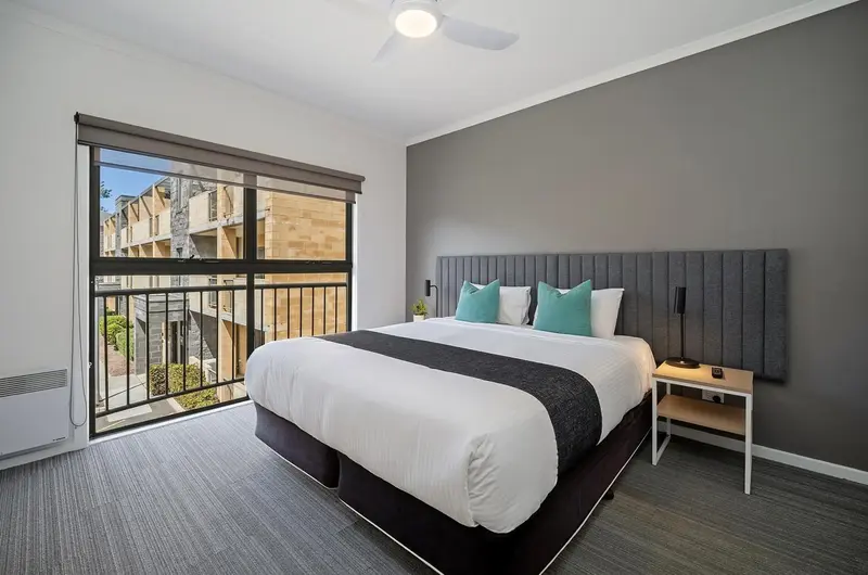 Une chambre moderne avec un grand lit et une vue sur l'extérieur.