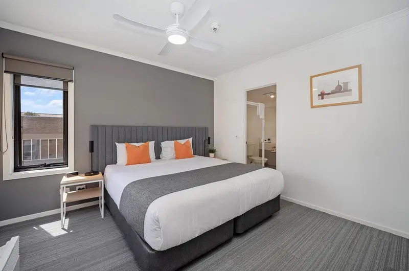 Chambre moderne avec un lit double et une décoration sobre.