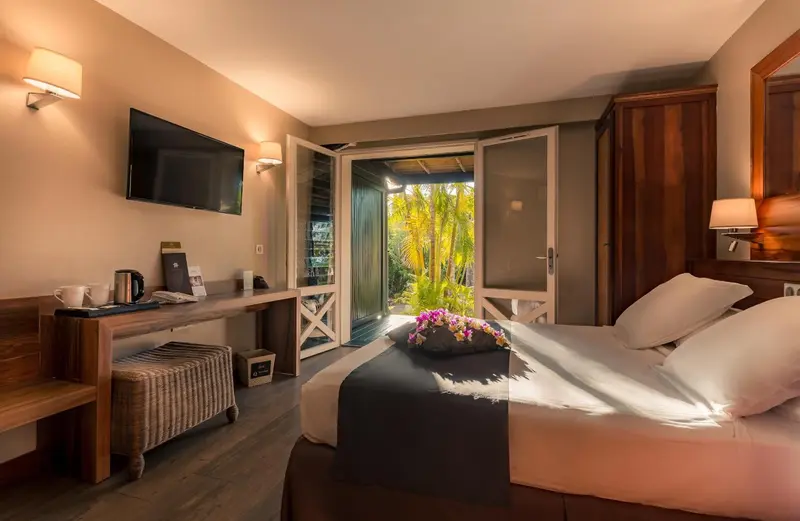 Une chambre lumineuse avec un grand lit et un accès à une terrasse.