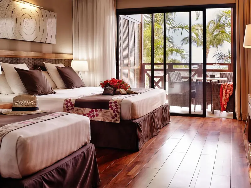 Une chambre avec un grand lit et un accès à une terrasse.
