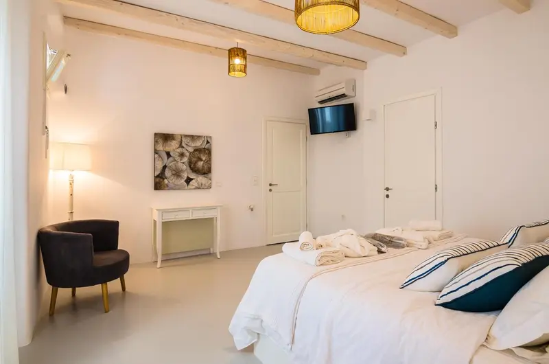 Une chambre lumineuse avec un lit fait et un coin lecture.