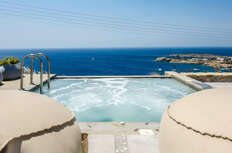 Jacuzzi extérieur avec vue sur la mer et le littoral rocheux.