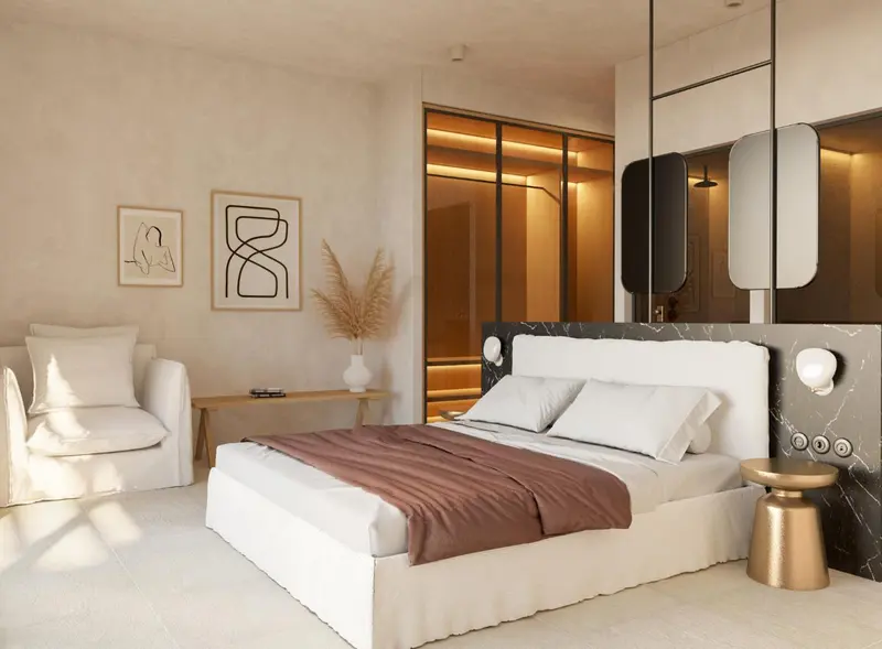 Une chambre lumineuse avec un grand lit et un fauteuil.