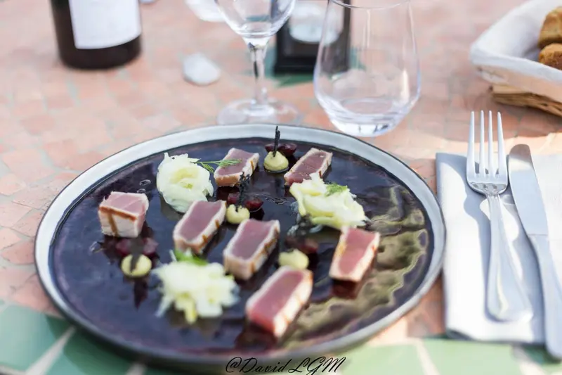Assiette de poisson cru présentée avec une garniture colorée.