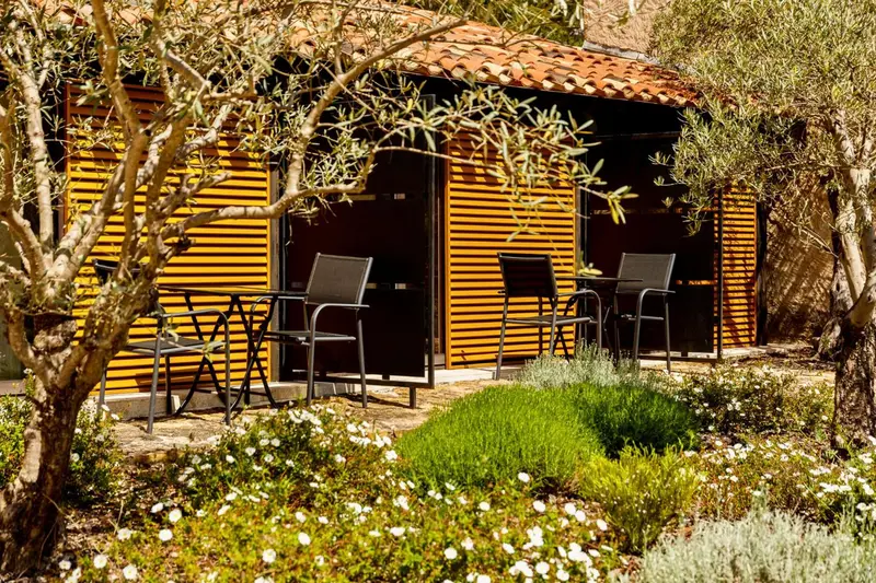 Terrasse avec tables et chaises devant des bâtiments en bois.