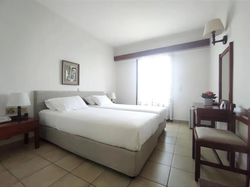 Une chambre lumineuse avec un grand lit et une coiffeuse.