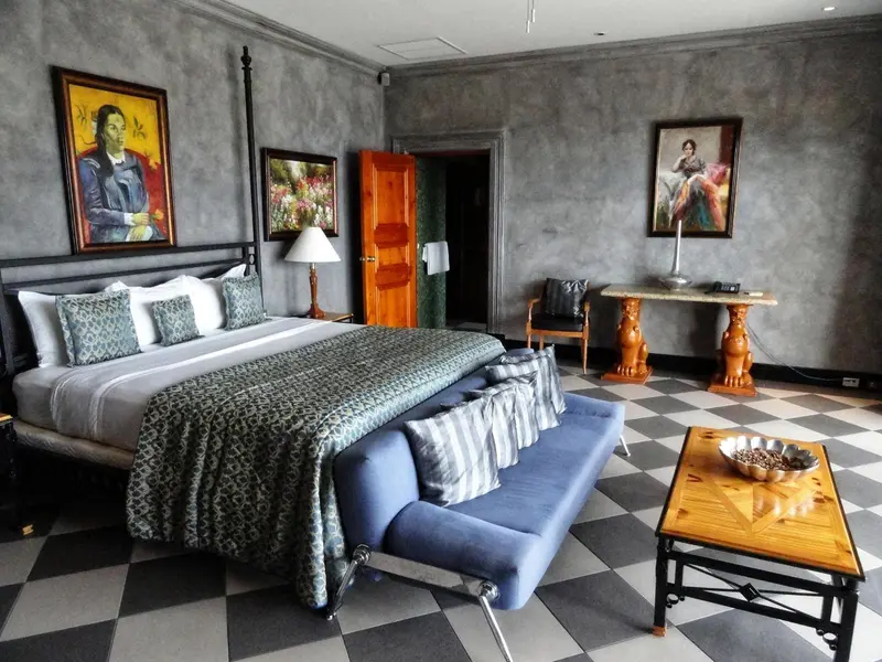 Une chambre spacieuse avec un grand lit et un canapé bleu.