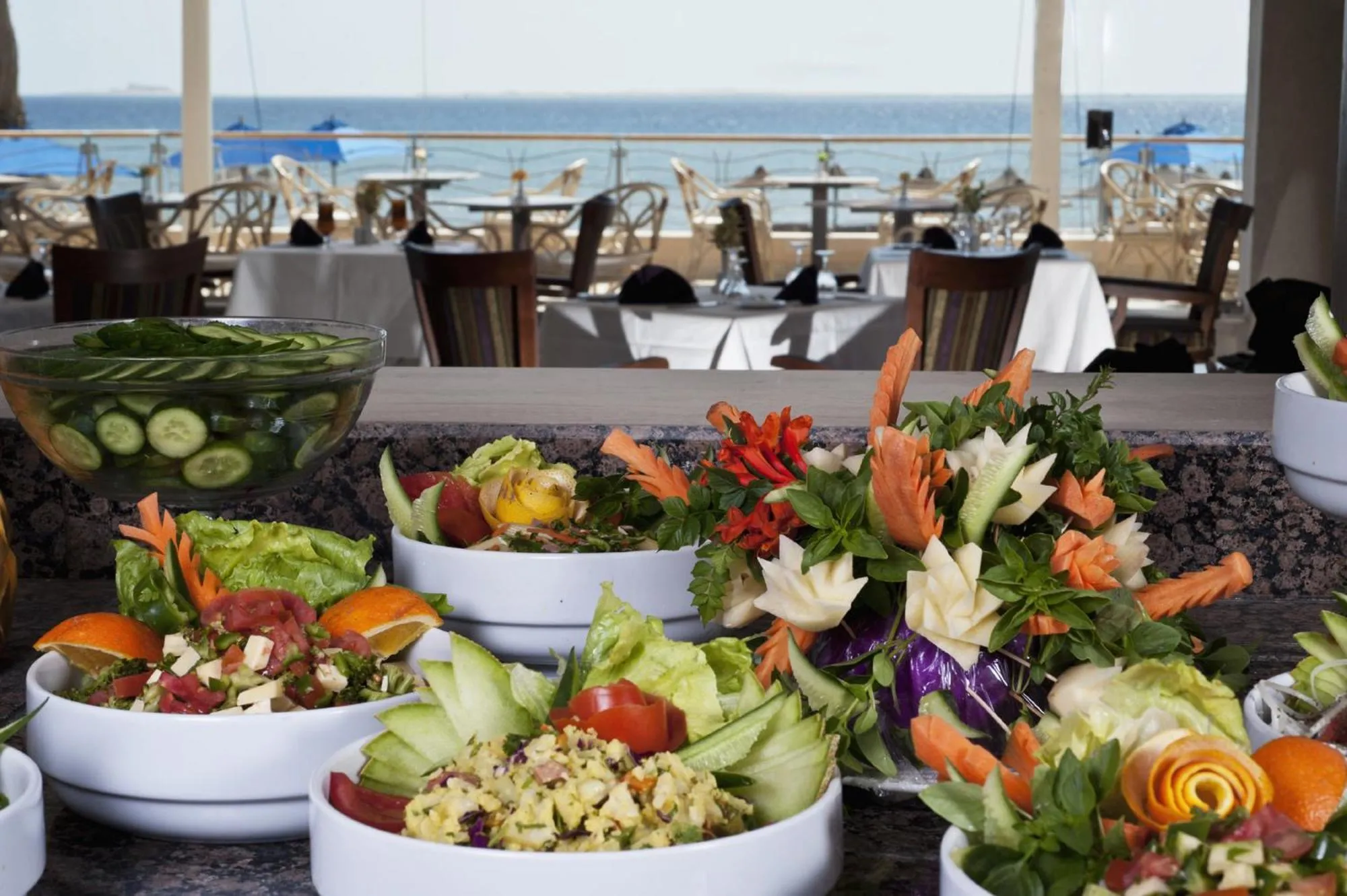 Un buffet de salades colorées est présenté sur un comptoir en plein air.