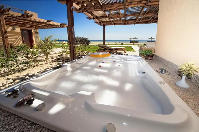 Un jacuzzi extérieur offre un moment de détente avec vue sur la mer.