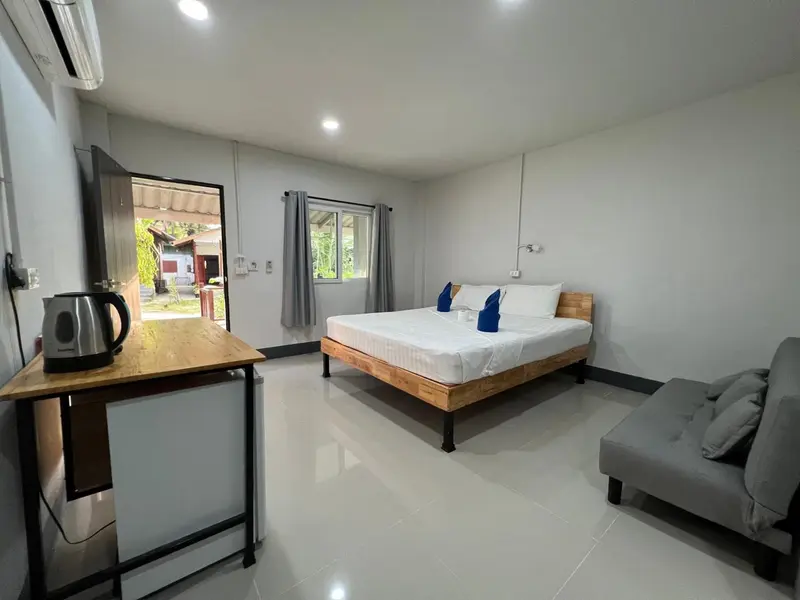 Une chambre lumineuse avec un lit double et un coin salon.