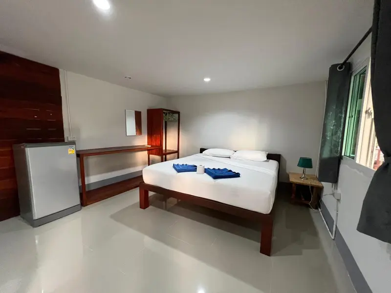 Une chambre lumineuse avec un grand lit recouvert d'une courtepointe blanche.