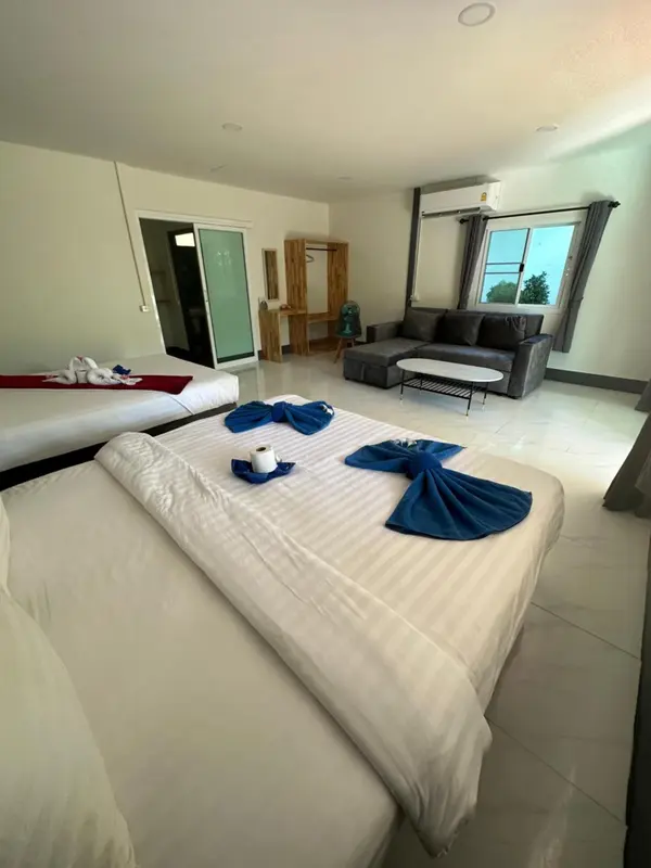 Chambre lumineuse avec lits décorés et espace détente.