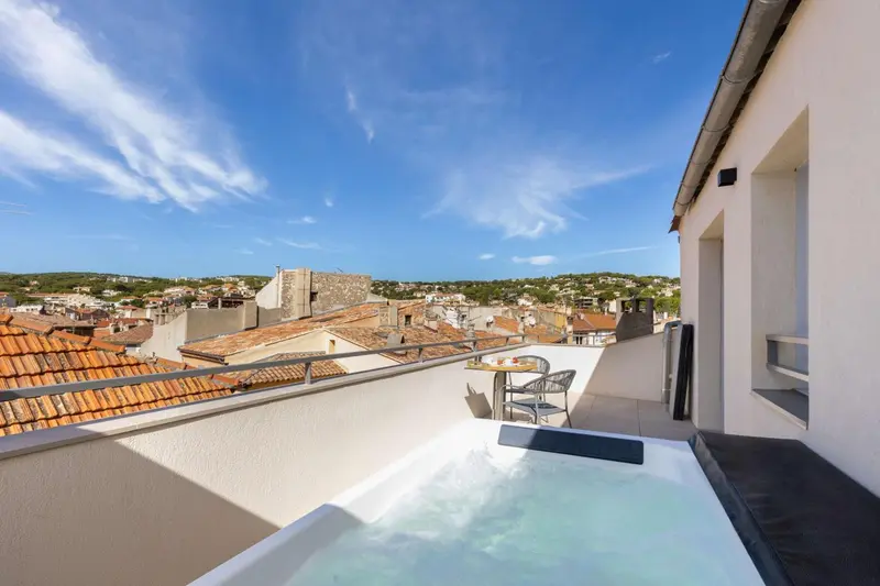 Terrasse avec jacuzzi et vue sur la ville.