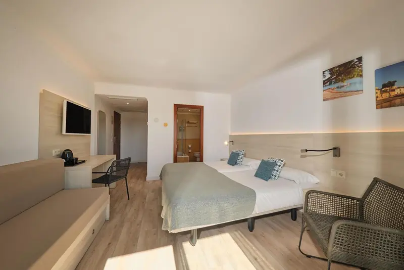 Chambre lumineuse avec un lit double et un espace détente.
