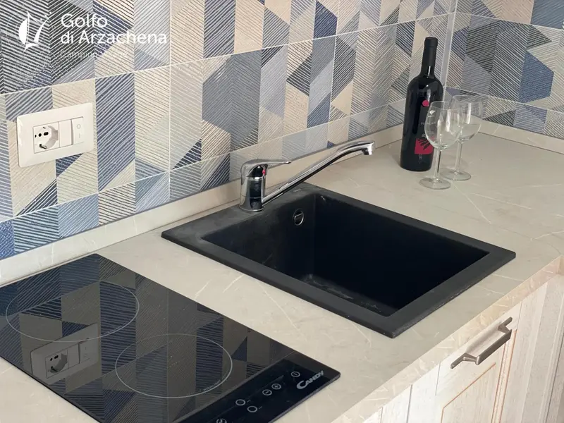 Un plan de travail de cuisine avec un robinet, un évier et une plaque de cuisson.