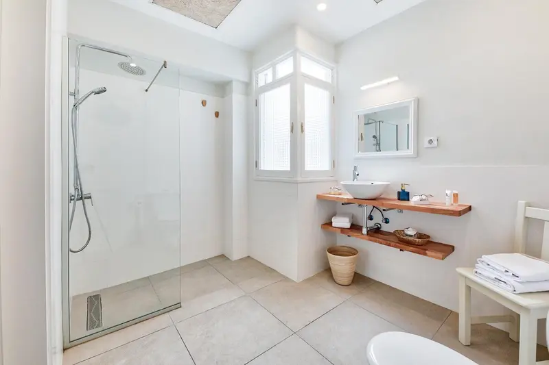 Une douche à l'italienne moderne dans une salle de bain lumineuse.